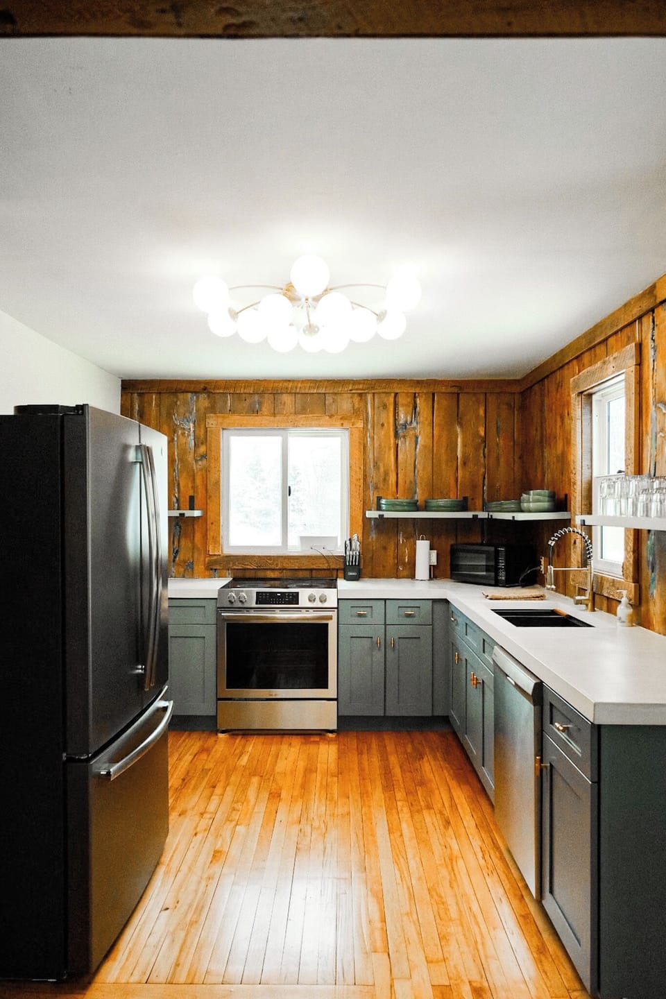 Rustic-modern kitchen with stainless appliances, concrete counter tops and original warm wood finishes