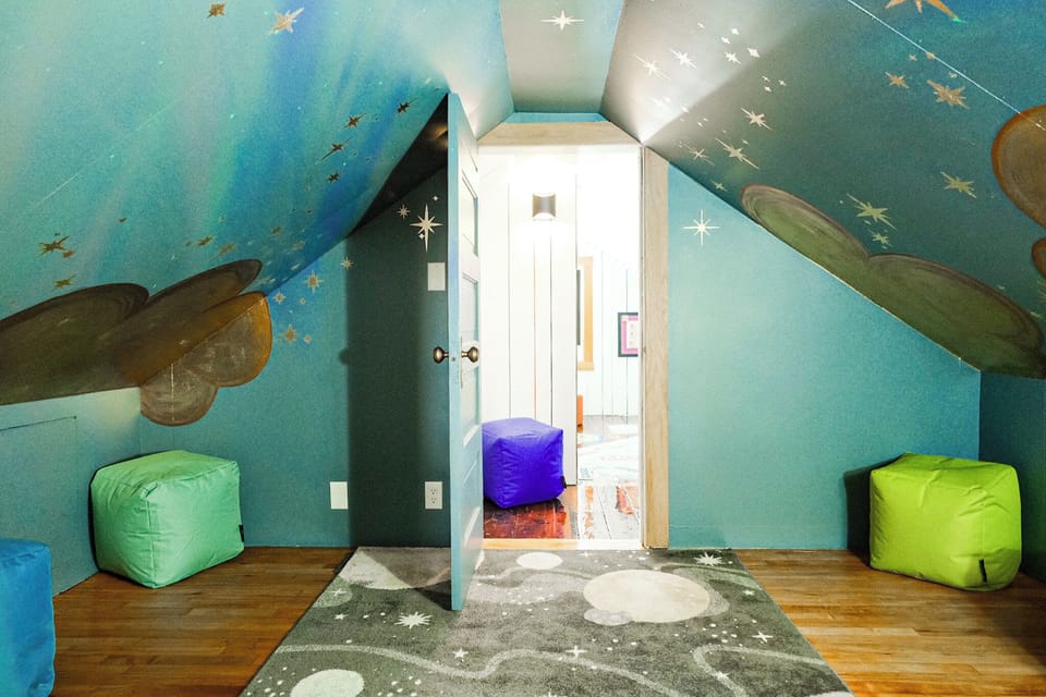 Whimsical space-themed attic lounge with beanbags and celestial decor