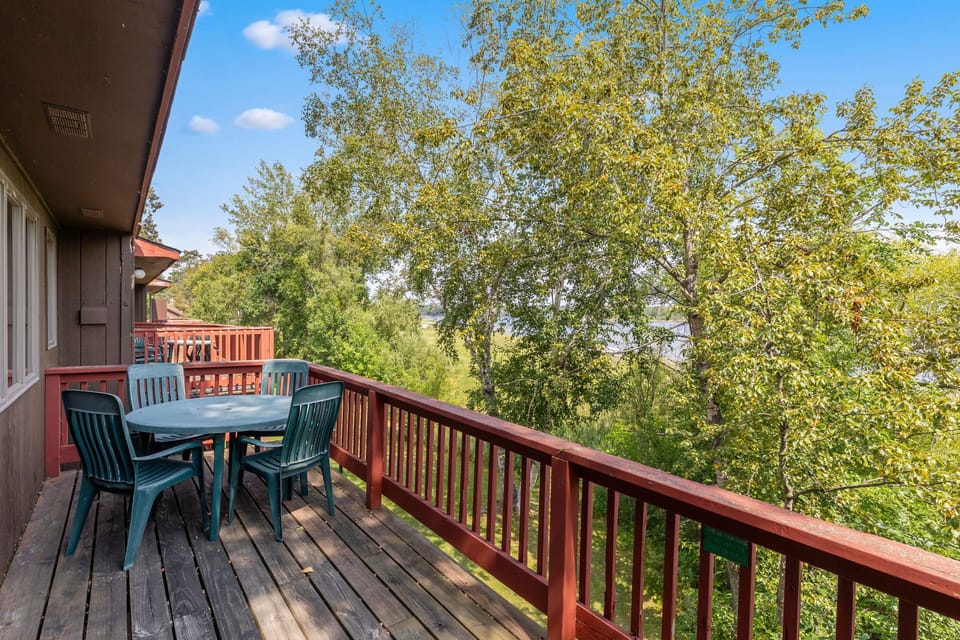 Enjoy serene views from your private balcony, surrounded by lush trees and vibrant blue skies.