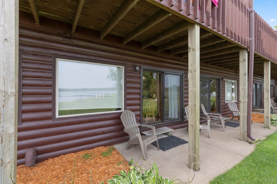 Covered patio with seating, offering a shaded retreat and views of the lake.