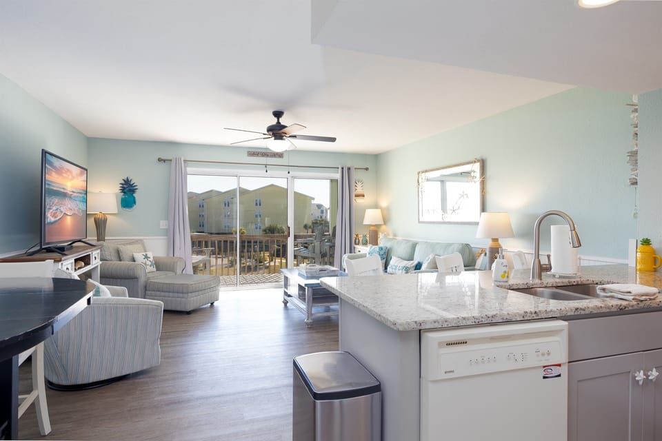 Enjoy an open flow from the kitchen into the sunlit living space, perfect for relaxing and gathering after a day at the beach