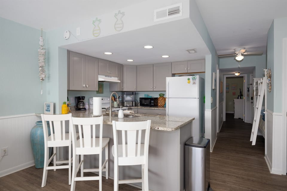 Updated kitchen with granite counters, ample storage, and a convenient breakfast bar overlooking the hallway