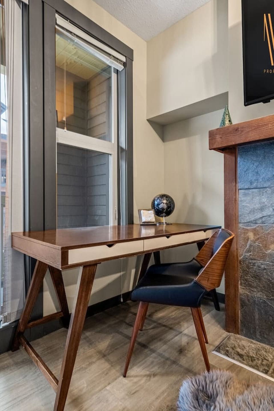 Living area/studio space with a gas-lit fireplace, dedicated workstation, access to the private balcony and a pull-out sleeper sofa (all linens provided.)
