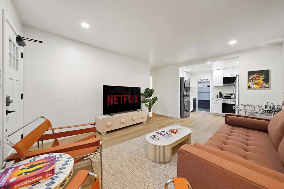 Relax in the airy living room with large windows and soft tones.