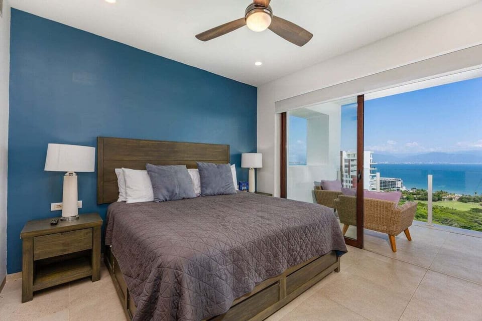 A contemporary bedroom featuring a deep blue accent wall and a dark wood bed frame with neutral bedding.