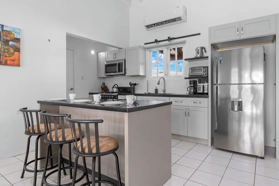 The heart of your home away from home! This fully-equipped kitchen features a stainless-steel fridge and a spacious island with seating for three—perfect for quick breakfasts or preparing a gourmet meal.