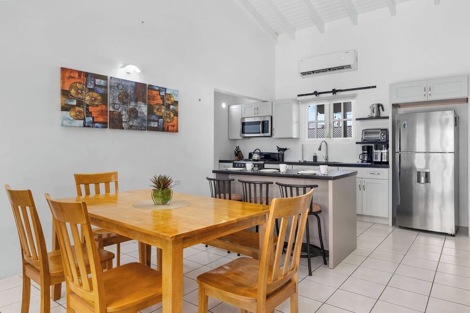 Share a meal, make memories. ???? Our spacious wooden dining table is the perfect spot for family dinners, game nights, or gathering for a post-beach coffee. Enjoy the open view into the modern kitchen while you dine!
