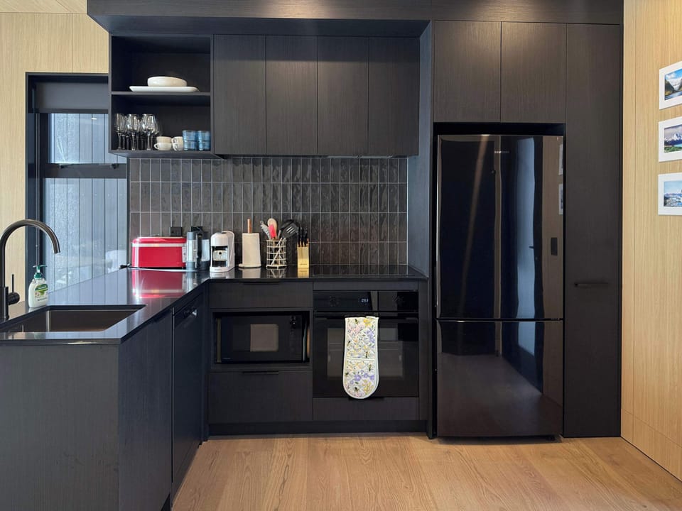 Modern kitchen with sleek black cabinetry and full appliances