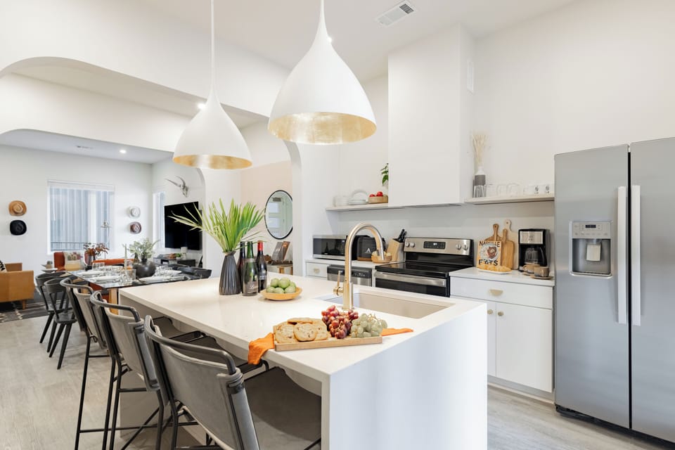 Modern, fully equipped kitchen features an island and stainless steel appliances.