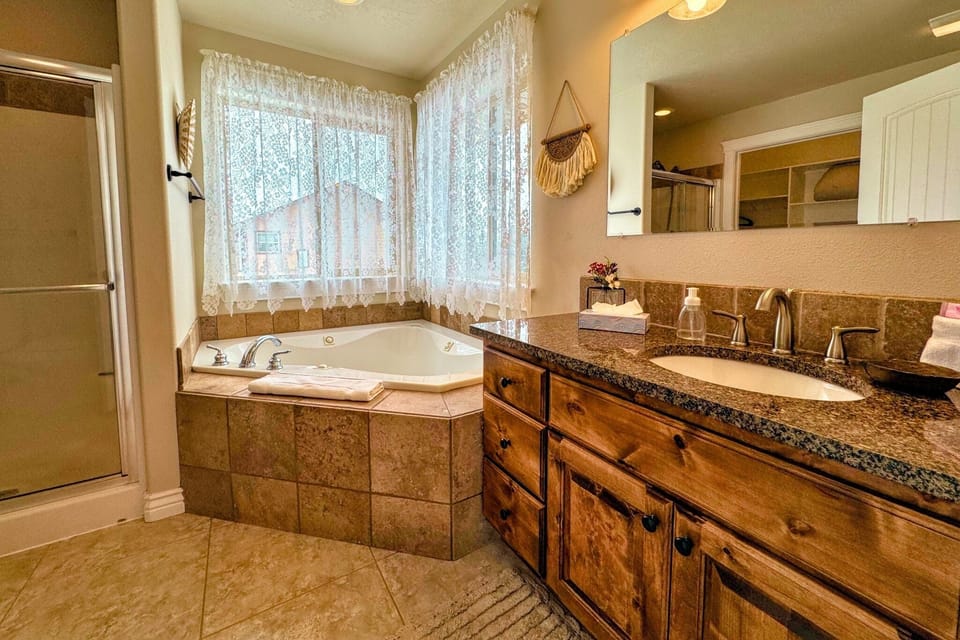 The primary en suite enjoys a large vanity, a luxurious jetted tub, and access to the walk-in closet.