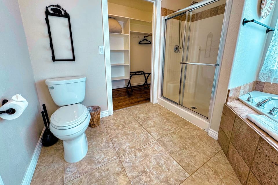 The primary en suite enjoys a large vanity, a luxurious jetted tub, and access to the walk-in closet.