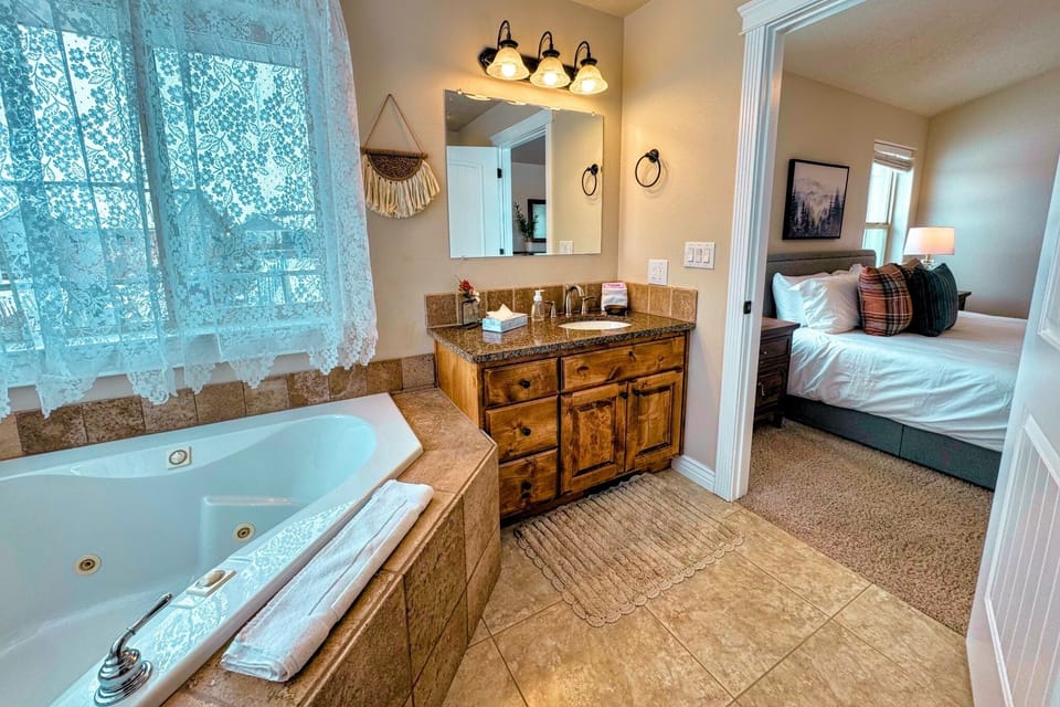 The primary en suite enjoys a large vanity, a luxurious jetted tub, and access to the walk-in closet.