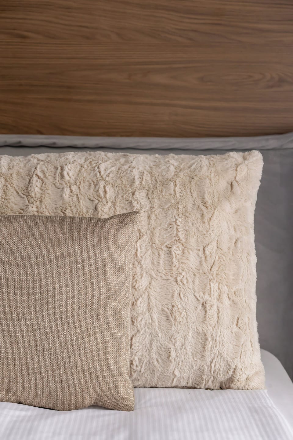 A close-up detail of decorative pillows on the bed. The textures add warmth and a cozy atmosphere.
