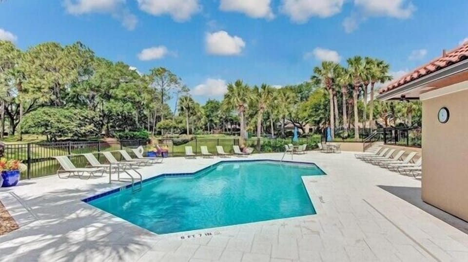 Sparkling outdoor pool surrounded by lush greenery, perfect for sunny afternoons and laid-back lounging.
