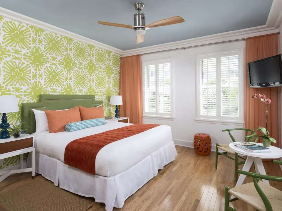 Sunny room with plush bed, green decor and coral curtains