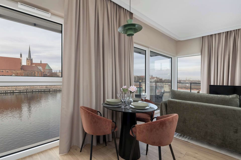 The dining table set by the panoramic windows lets you enjoy meals bathed in daylight and accompanied by a view that adds effortless charm to every moment.