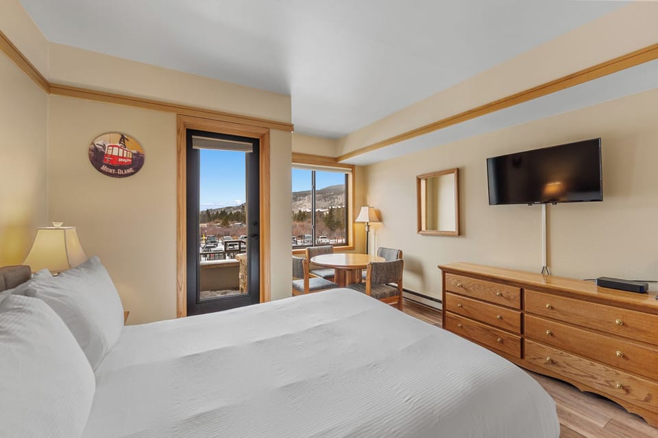Relax in your cozy bedroom with mountain views, warm wood furnishings, and modern amenities creating the perfect retreat.