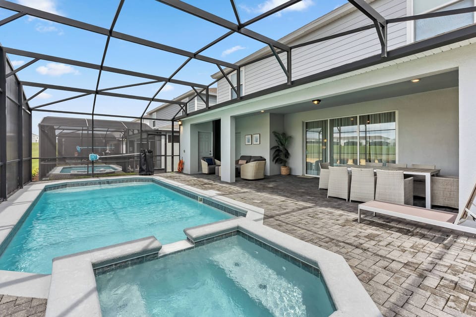 Discover your private oasis with a sparkling pool and inviting hot tub, surrounded by stylish pavers and a spacious outdoor dining area. Expansive windows let in natural light, creating a fresh and modern atmosphere just for you.