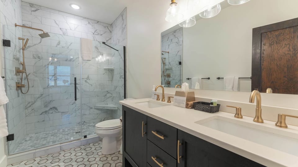 Beautifully finished full bathroom featuring a spacious walk-in shower with detailed tilework, contemporary vanity, modern fixtures, and clean finishes for a comfortable guest experience.