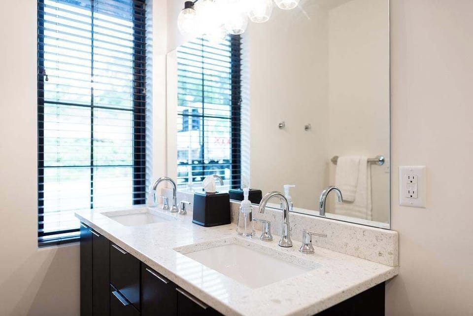 Fresh and spacious bathroom with a large vanity, modern fixtures, and natural light.