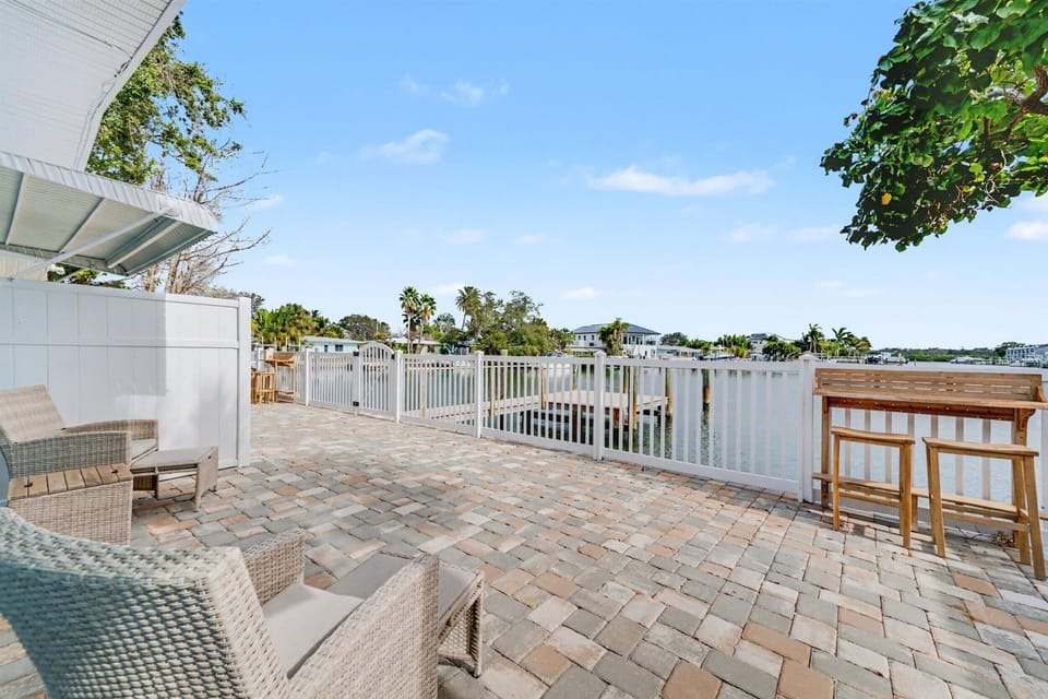 Step out onto your spacious waterfront patio where peaceful canal views and gentle breezes await. Wicker seating invites you to unwind while the tiki bar sets the scene for sunset cocktails by the water.