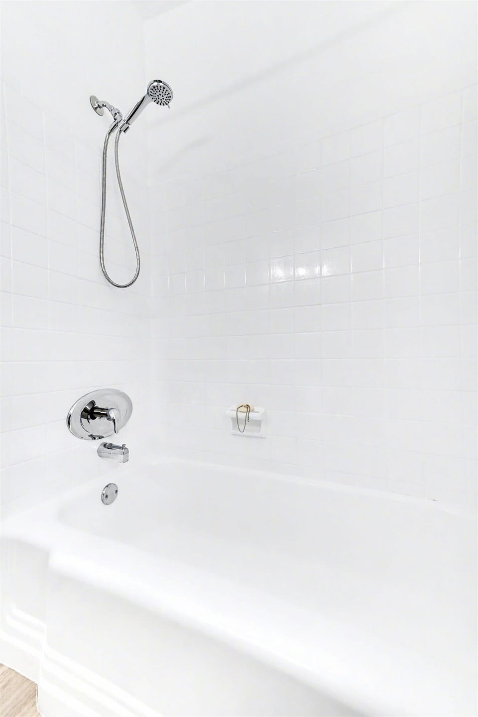 A pristine white bathtub with a sleek rainfall showerhead awaits you—perfect for unwinding after exploring the area.