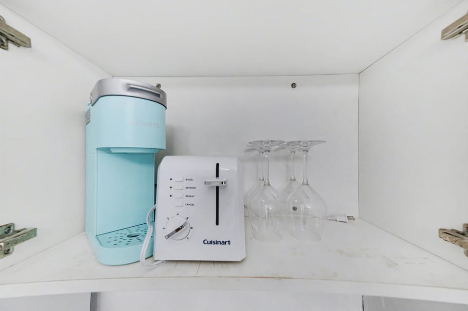 Your morning coffee is calling—this sleek setup includes a modern single-serve brewer and wine glasses, ready for your favorite beverages any time of day.