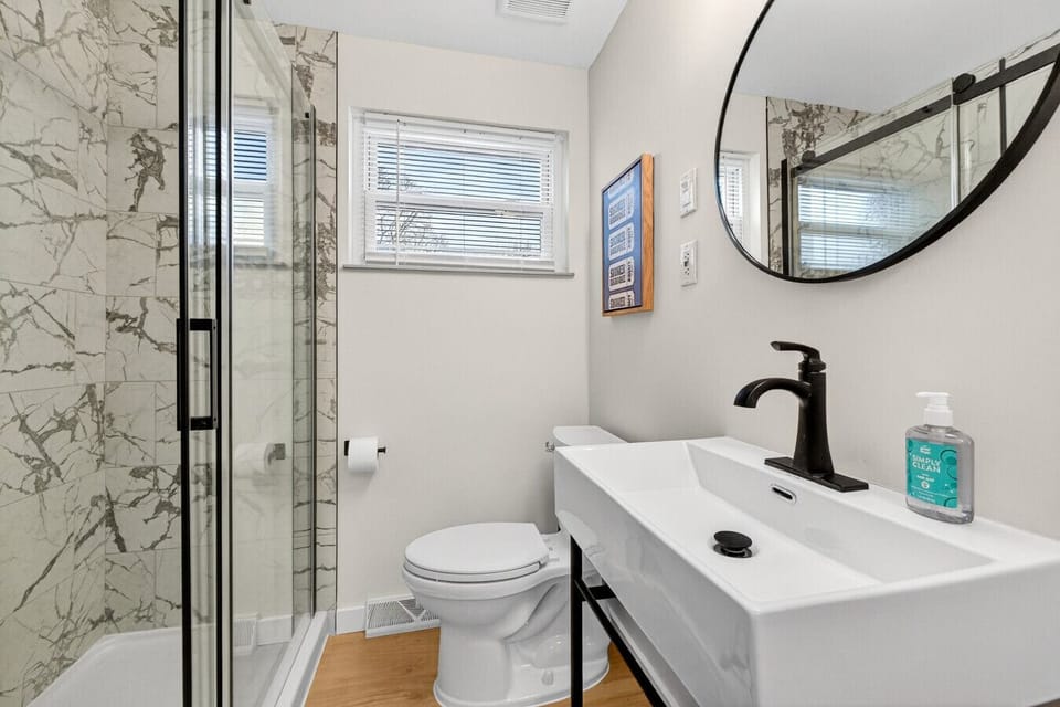 Updated bathroom with modern vanity and glass-enclosed shower.
