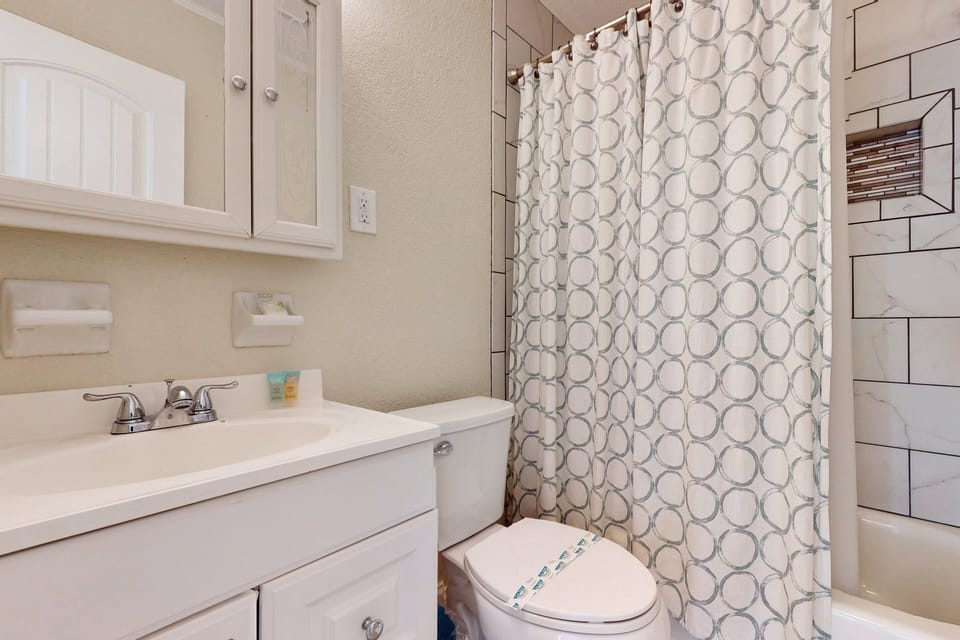 Refresh during your beach stay in this clean, updated bathroom featuring a modern vanity and walk-in shower. A comfortable space to rinse off and relax after sunny beach days.