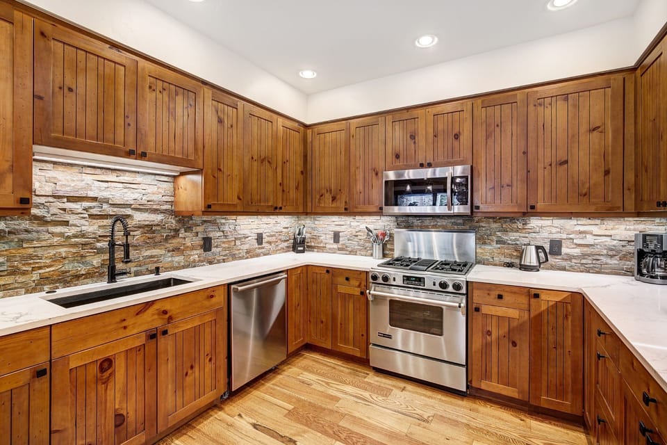 A chef's dream, this kitchen showcases a seamless blend of wood and stone, providing both functionality and aesthetic appeal in a warm, inviting environment.