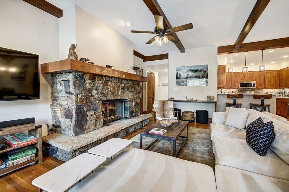 This inviting lounge area, adorned with rustic decor, serves as the perfect retreat after a day on the slopes, complete with a sleek layout that connects to the kitchen.