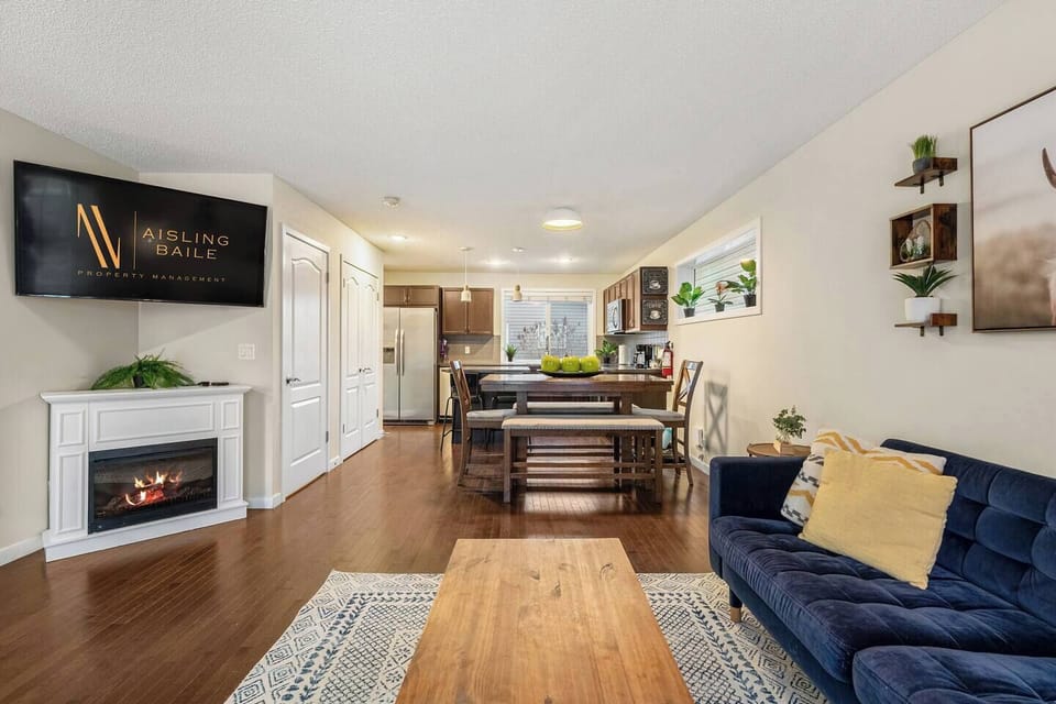 Main floor living room with a cozy couch, tons of board games, an electric fireplace, and a 55` Smart/Roku TV.