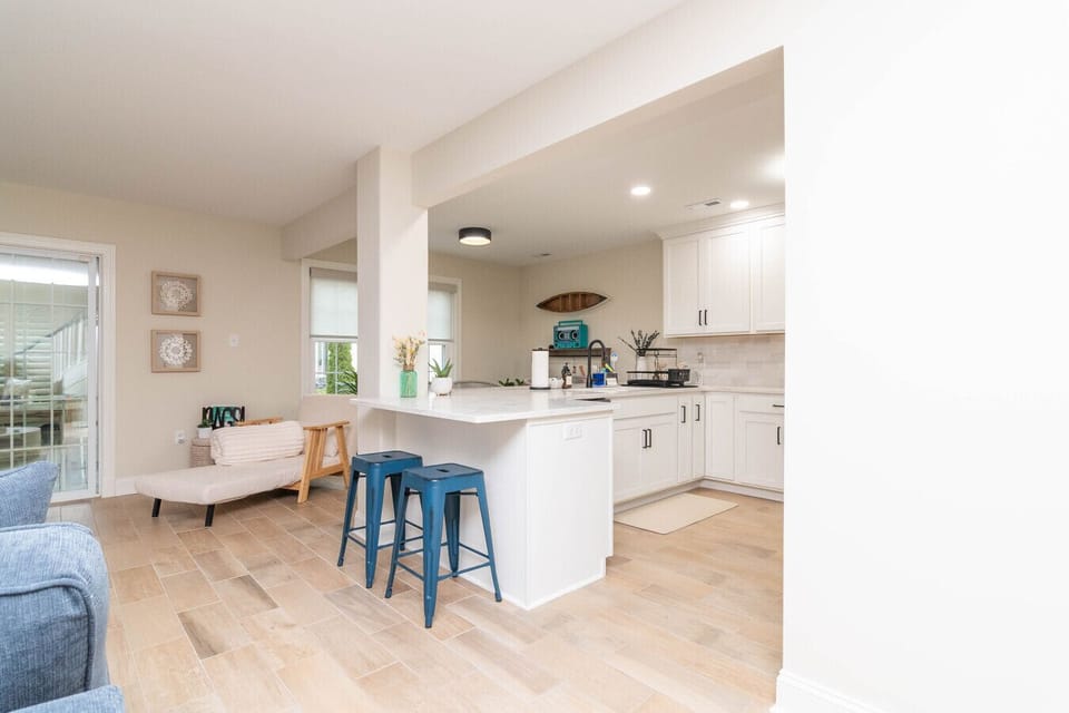 A chef-style kitchen featuring sleek white cabinetry and a breakfast bar for social meal prep.