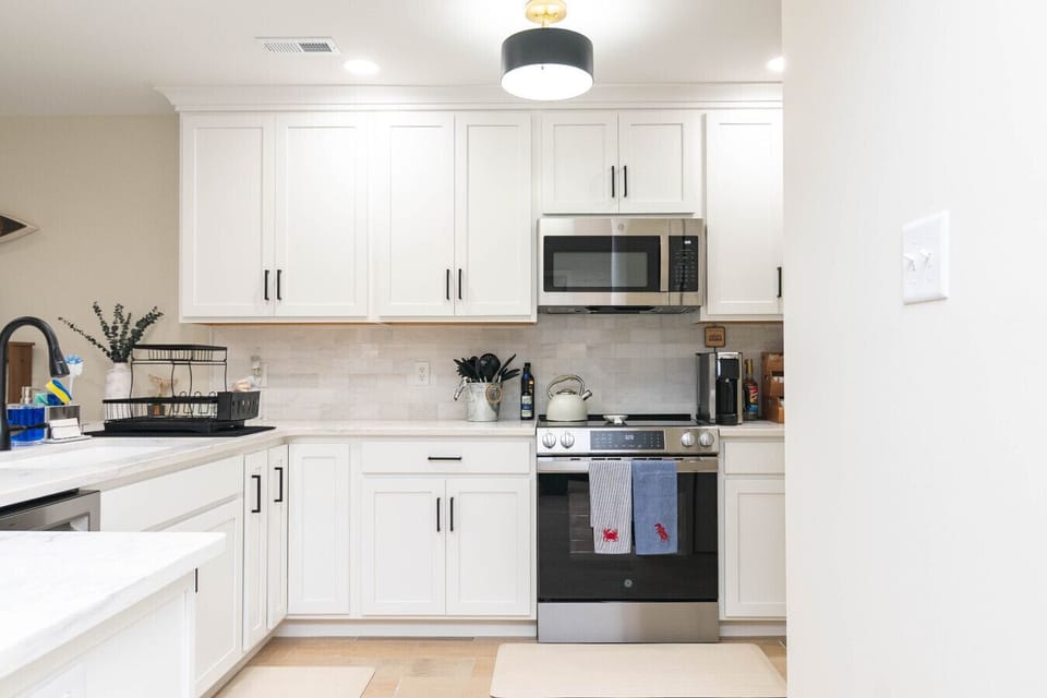 Chef-style kitchen with white cabinetry and breakfast bar.