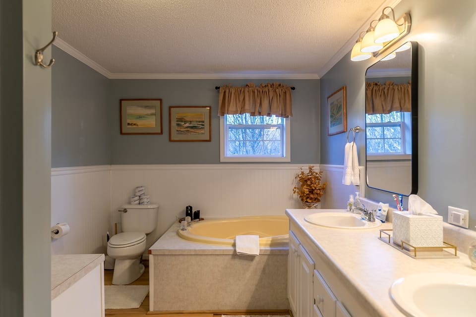 Soak the day away in the spacious bathroom at Our Happy Nest, complete with a corner soaking tub and double sinks.