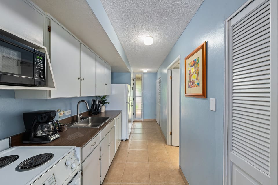 Fully equipped kitchen with white appliances and cabinetry
