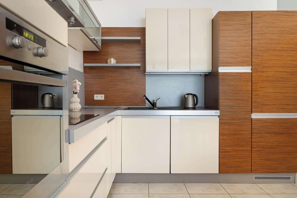 Sleek kitchenette with glossy cabinets and refined minimalist details.