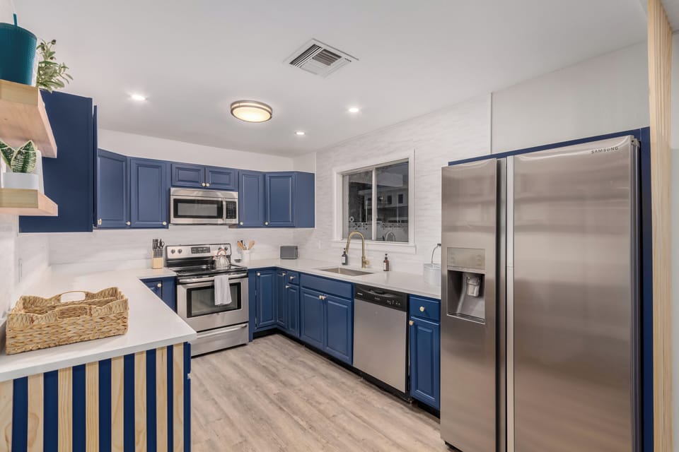 Modern fully stocked kitchen with stainless steel appliances.