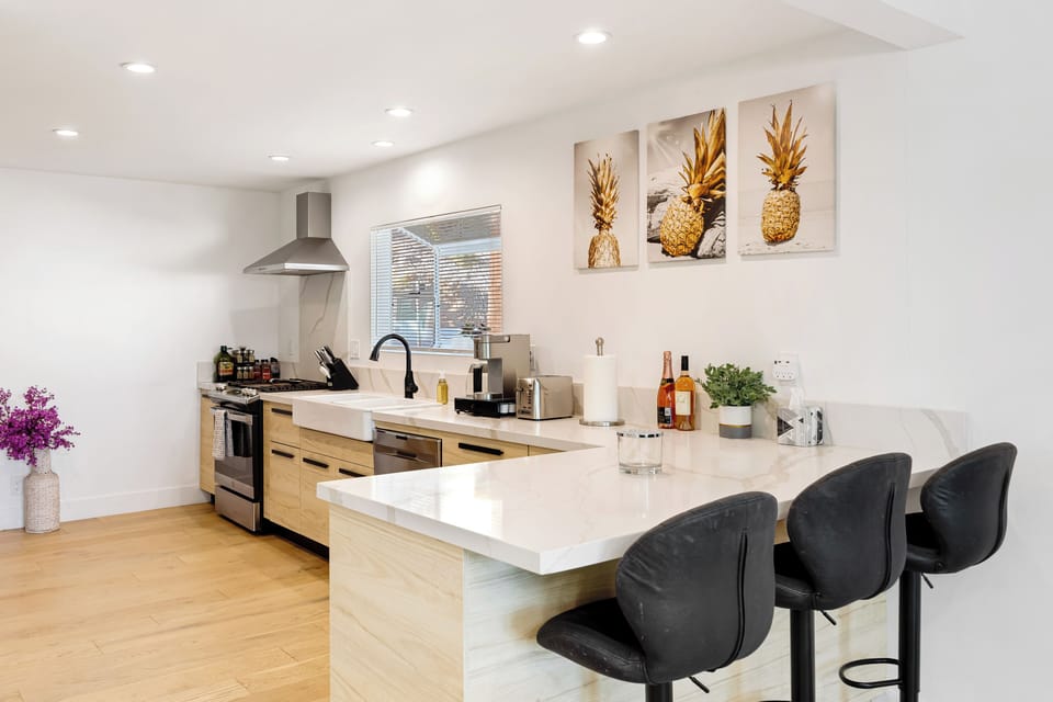 Kitchen with stainless steel hood and bright white countertops.