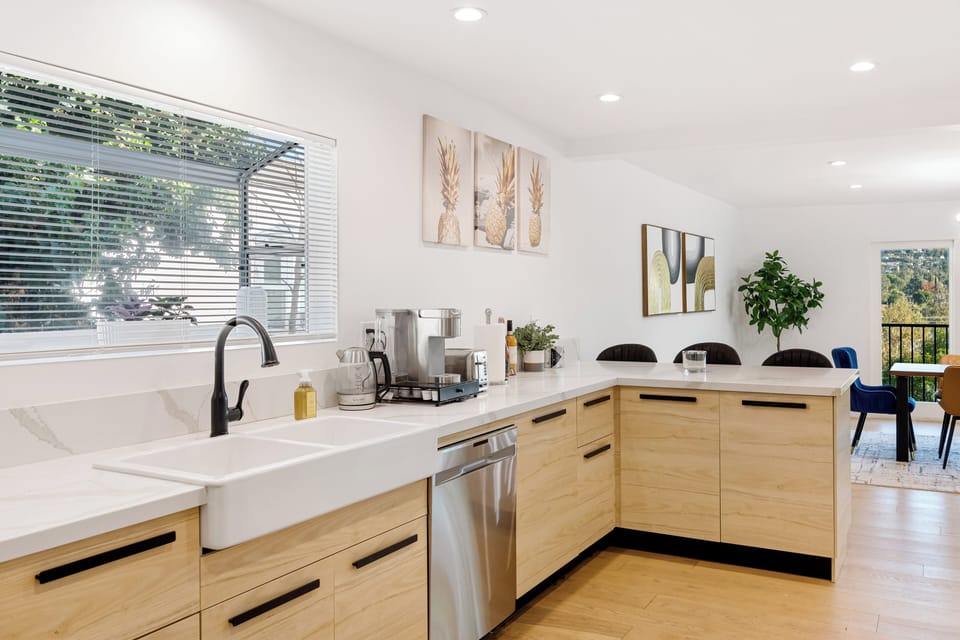 Sunlit kitchen with farmhouse sink and window view.