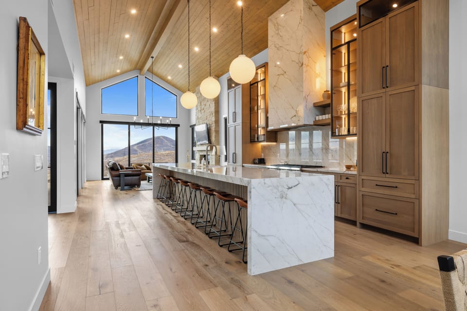 Grand open-concept kitchen with a waterfall island and vaulted ceilings.