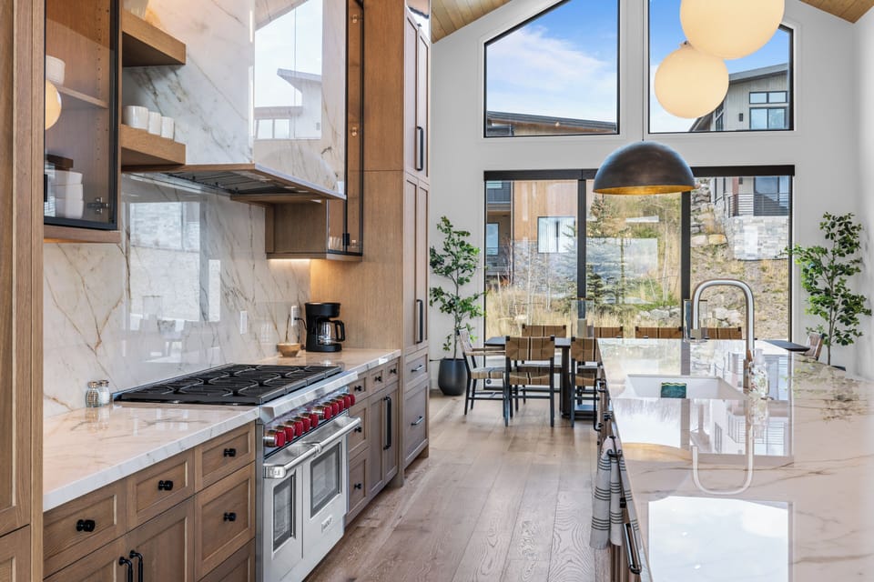 Modern kitchen design highlighted by dramatic lighting and soaring ceilings.