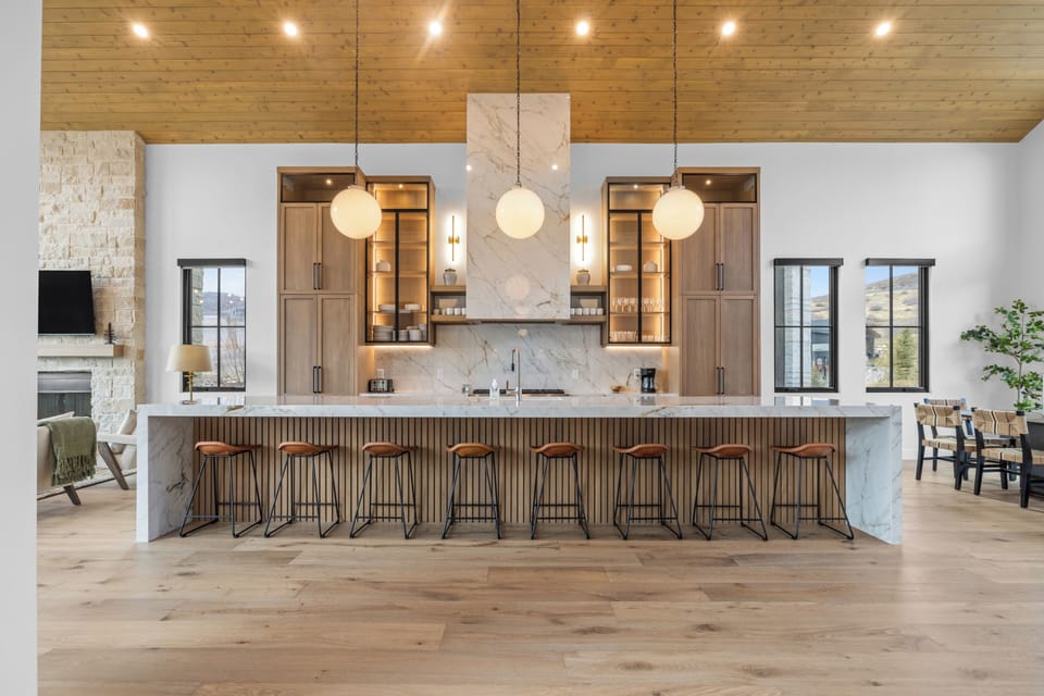 Sleek chef’s kitchen with a waterfall island and seating for the whole group.