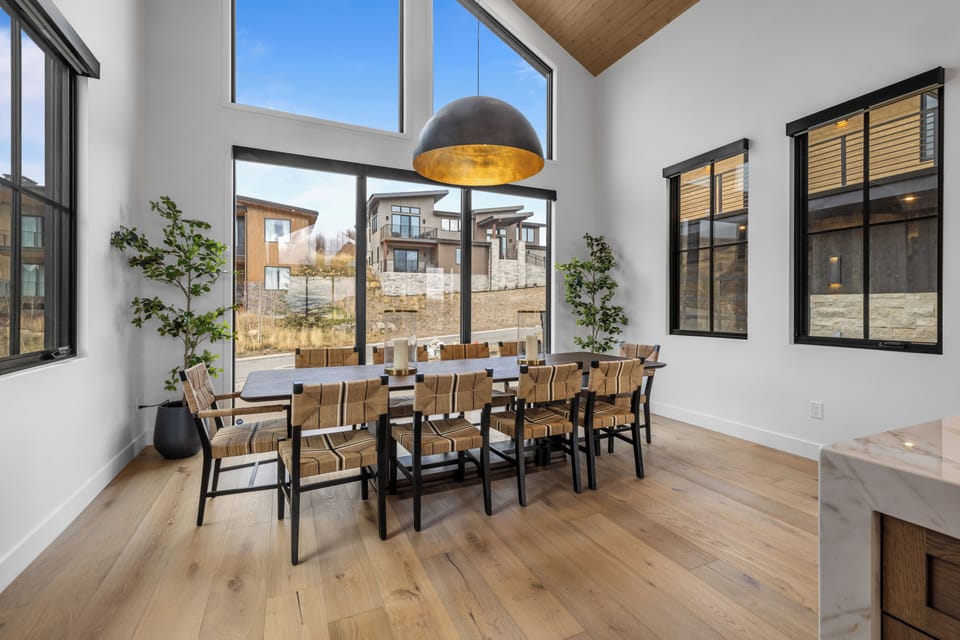 Bright dining space with floor-to-ceiling windows and mountain views.