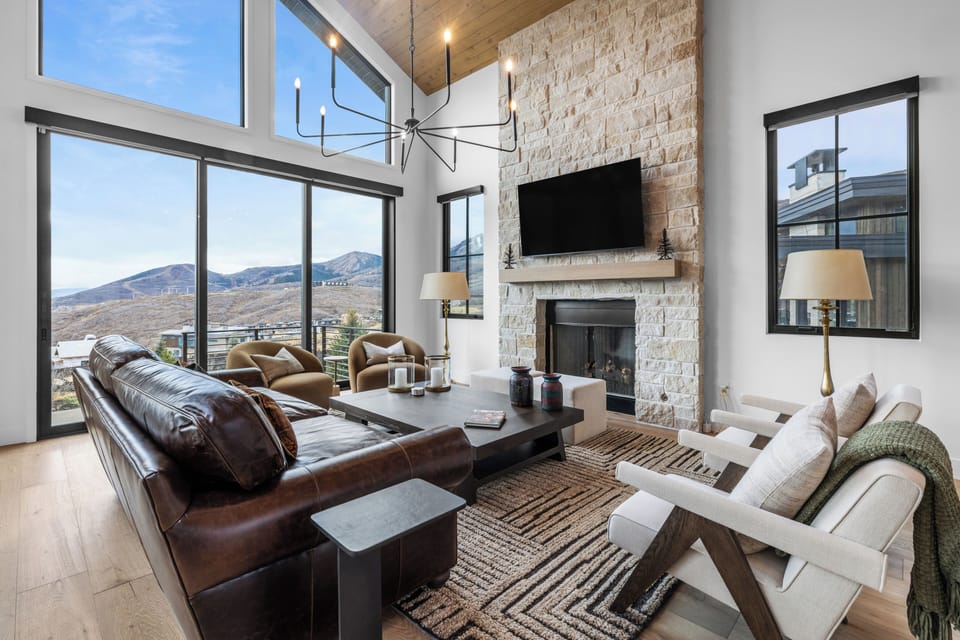 Bright, modern living room with mountain views and a stunning stone fireplace.