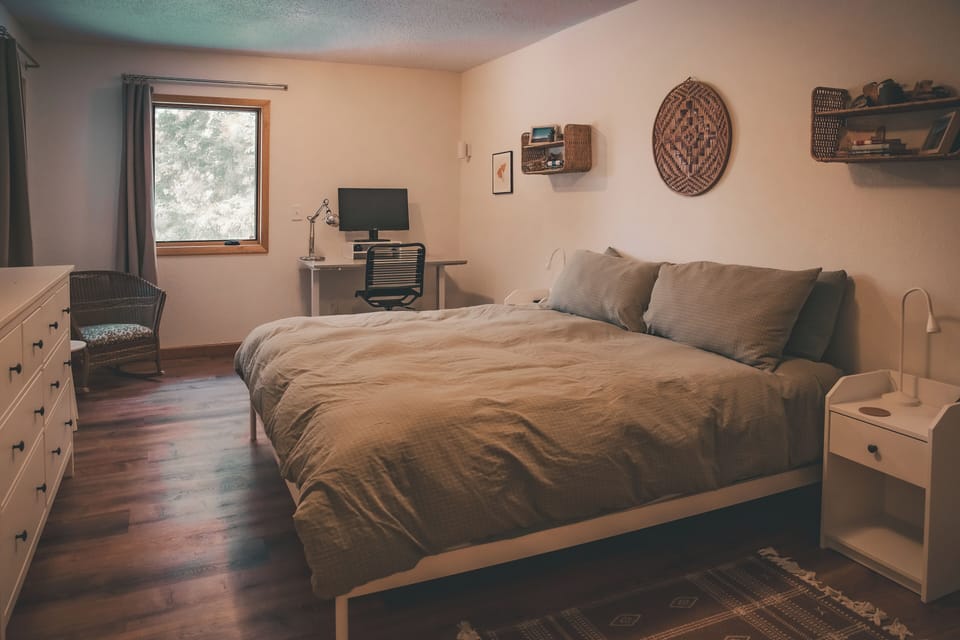 Soothing sleeping spaces, with trees out the widow.
