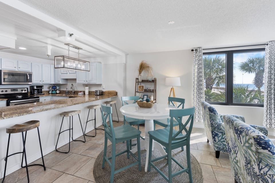 Your bright coastal retreat features an open kitchen, charming dining nook, and palm-framed ocean views that invite relaxation.