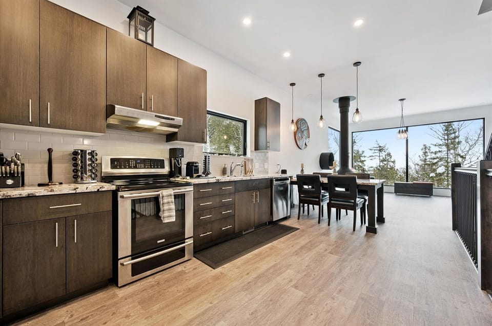 A sleek, open kitchen with stainless appliances, modern cabinetry, and an easy flow into the dining and living areas.