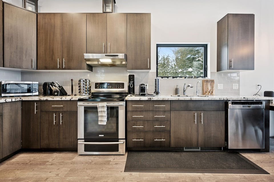 Clean lines and functional design define this bright kitchen workspace, with forest views and everything you need for a comfortable stay.