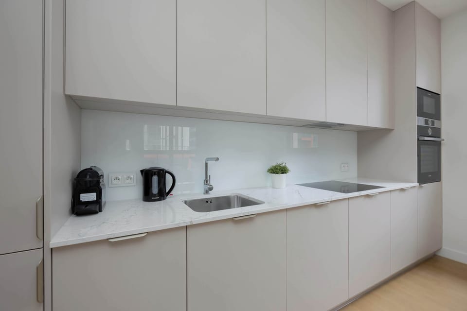 A close-up view of the kitchen countertop with a kettle, toaster, and coffee maker. The space is designed for convenient daily use.